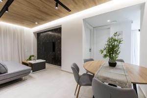 a living room with a dining room table and a couch at Varkiza Luxury Suites by Raise in Vari