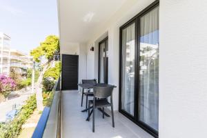 a balcony with a table and chairs on it at Varkiza Luxury Suites by Raise in Vari