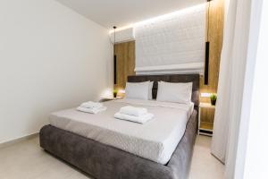 a bedroom with a bed with two towels on it at Varkiza Luxury Suites by Raise in Vari