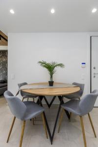 a dining room table with two chairs and a potted plant at Varkiza Luxury Suites by Raise in Vari