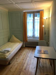 a small room with a bed and a table at Hotel Rebstock Meiringen in Meiringen