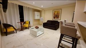 sala de estar con sofá y sillas en Apartamentos Valery en Trujillo