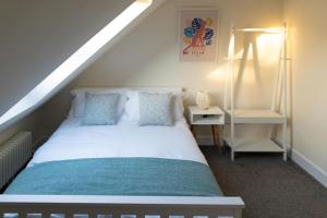 ein Schlafzimmer mit einem weißen Bett und einer Leiter in der Unterkunft Modern cottage WiFi Free Parking in Penwortham