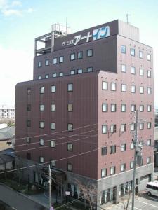 a tall building with a sign on the top of it at Terminal Art Inn in Niigata