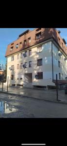 a large white building with a brown roof at Apartman Mila Vlašić in Šišava +8 photos