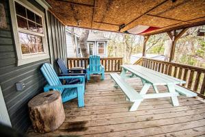 two blue chairs and a picnic table on a porch at Lake Texoma's Barn-dominum in Pottsboro in Pottsboro