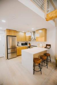 a kitchen with a white counter and stools in it at Villa Costello, in Kingston