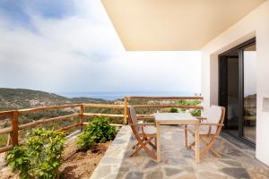 balcón con mesa, sillas y vistas al océano en Monopati Eco Villas, en Raches