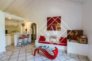 ein Wohnzimmer mit einem roten Sofa und einem Tisch in der Unterkunft Exceptional 6 bed-rooms Villa at Anse Marcel in Saint Martin