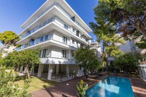 un edificio de apartamentos con piscina frente a él en Varkiza Luxury Suites en Vari