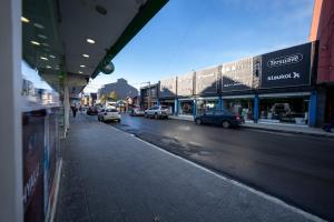 a city street with cars parked in front of buildings at Appartement in the Main Street with elevator access in Ushuaia