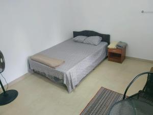 a small bedroom with a bed and a night stand at Barrett Accommodation Rooms in Suva