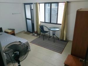 una camera con letto, tavolo e sedie di Barrett Accommodation Rooms a Suva