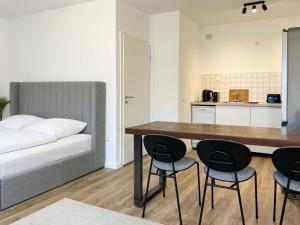 1 dormitorio con 1 cama, mesa y sillas en Schöne Ferienwohnung im Zentrum mit Self Check-In und Free Wifi, en Essen