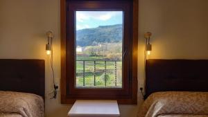 ventana en una habitación con vistas a la montaña en ALOJAMIENTO XELO, en Porriño