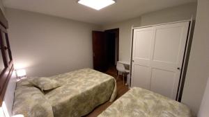 1 dormitorio pequeño con 2 camas y puerta en ALOJAMIENTO XELO, en Porriño 10 fotos más