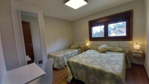Un dormitorio con dos camas y una ventana. en ALOJAMIENTO XELO, en Porriño