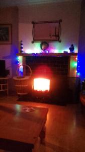 a living room with a fireplace with christmas lights at Moorings Greenway in Newport