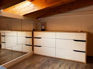 um quarto com armários brancos e um tecto de madeira em A&A Rooftop em Somma Lombardo