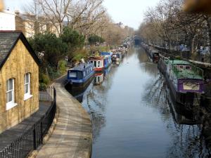 a river with boats parked on the side of it at Stunning property overlooking local park in London