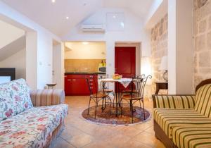 uma sala de estar com um sofá e uma mesa com cadeiras em Apartment Saraka em Dubrovnik