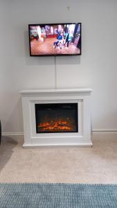 a fireplace with a flat screen tv on a wall at Couple's Retreat-West Kilbride in Seamill