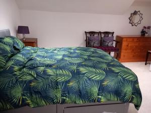 a bedroom with a bed with a blue comforter at Couple's Retreat-West Kilbride in Seamill