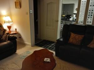 a living room with two leather chairs and a table at Couple's Retreat-West Kilbride in Seamill