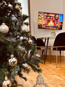 a christmas tree with ornaments on it in a living room at Apartment 5 min Schönbrunn Gloriette, Direct to City Center, Free Parking in Vienna