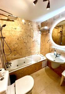 a bathroom with a tub and a sink and a bath tub at Elegant Palm Mar Apartment in Palm-Mar