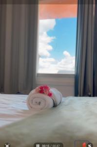a towel on a bed in front of a window at Piaui Apart Hotel in Teresina