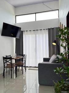 a living room with a couch and a table and chairs at Casa Gamboa, La Fortuna in Fortuna