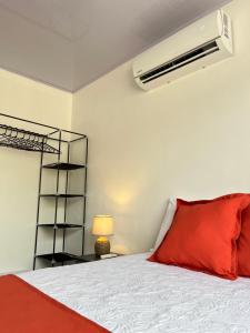 a bedroom with a bed with a red pillow at Casa Gamboa, La Fortuna in Fortuna