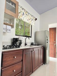 a kitchen with a stainless steel refrigerator and wooden cabinets at Casa Gamboa, La Fortuna in Fortuna