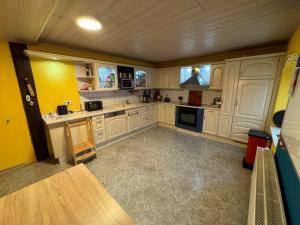 a large kitchen with yellow walls and white cabinets at Zimmer in Tangermünder Innenstadt in Tangermünde