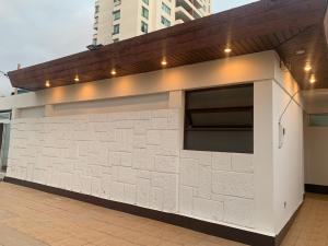 a white brick building with a garage at Península Hostel in Iquique
