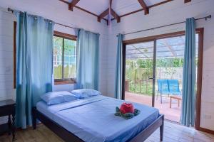 a bedroom with a bed and a large window at Casa Tulipan - Private 3bd, AC, Pool, Big Garden w' BBQ in Puerto Viejo