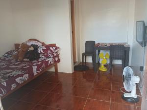 a bedroom with a bed with two stuffed animals on it at Llave's transient house in Nasugbu