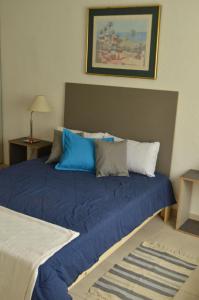 a bed with blue pillows on it in a room at SUNNY HOUSE BOULEVARES 4/5pax in Córdoba