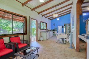 a living room with a table and a kitchen at Casa Tulipan - Private 3bd, AC, Pool, Big Garden w' BBQ in Puerto Viejo