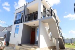 a white house with a staircase in front of it at Morris Multi in Dar es Salaam