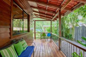 a porch with a blue couch on a wooden deck at Casa Tulipan - Private 3bd, AC, Pool, Big Garden w' BBQ in Puerto Viejo