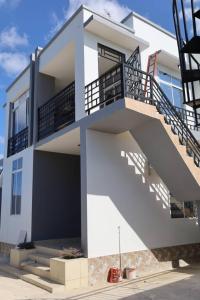 a white house with stairs on the side of it at Morris Multi in Dar es Salaam