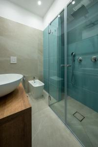 bagno con doccia in vetro e lavandino di B&B Corso Garibaldi 165 a Napoli