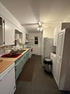 a kitchen with white cabinets and a sink and a refrigerator at The Versace House in Windsor