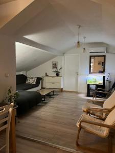 a living room with a bed and a flat screen tv at Apartman Gradina in Doboj