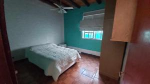 1 dormitorio con cama y pared verde en Alquilo Casa, 2 Dormitorios y 1 Baño en Maipú