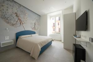 una camera con letto blu e bianco e TV di B&B Corso Garibaldi 165 a Napoli