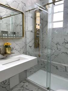 W łazience znajduje się umywalka i przeszklony prysznic. w obiekcie Luxury Living in the Heart of NY! w mieście Yonkers