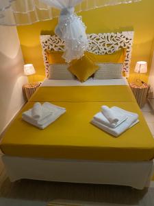 a bedroom with a yellow bed with towels on it at Chez Soul~Etage entier avec vue sur mer in Sainte-Rose